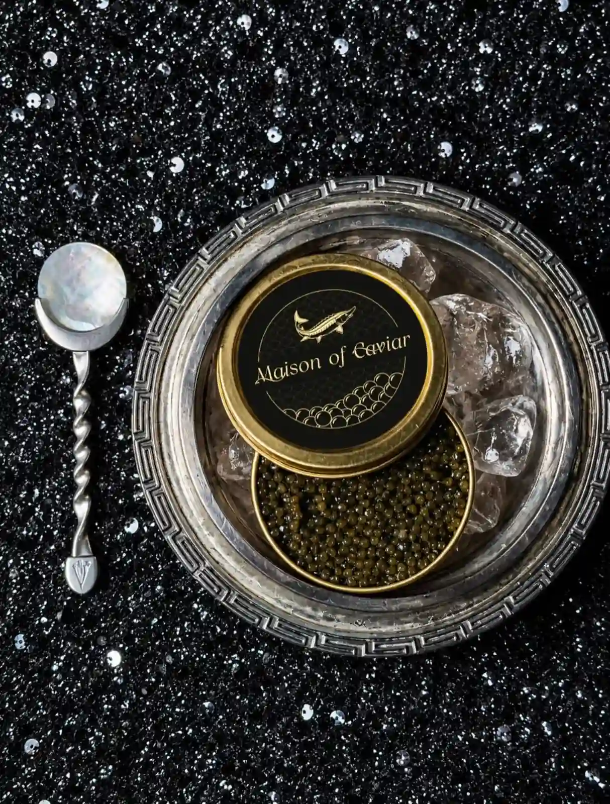 A Maison of Caviar tin served on ice in a silver bowl with a mother-of-pearl spoon